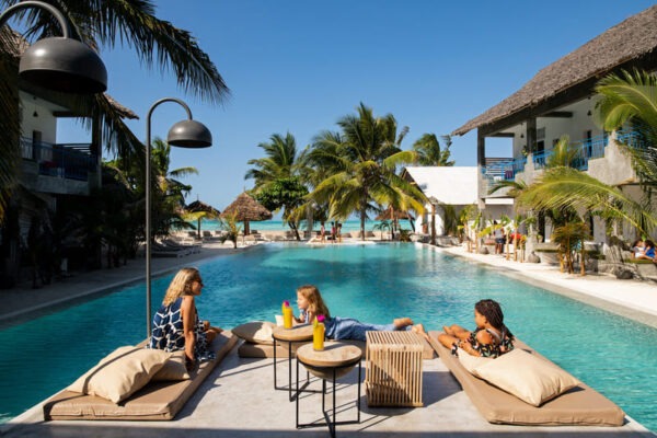 Vue d'ensemble du Casa Beach Hotel à Zanzibar : Piscine, palmier et chambres avec terrasse